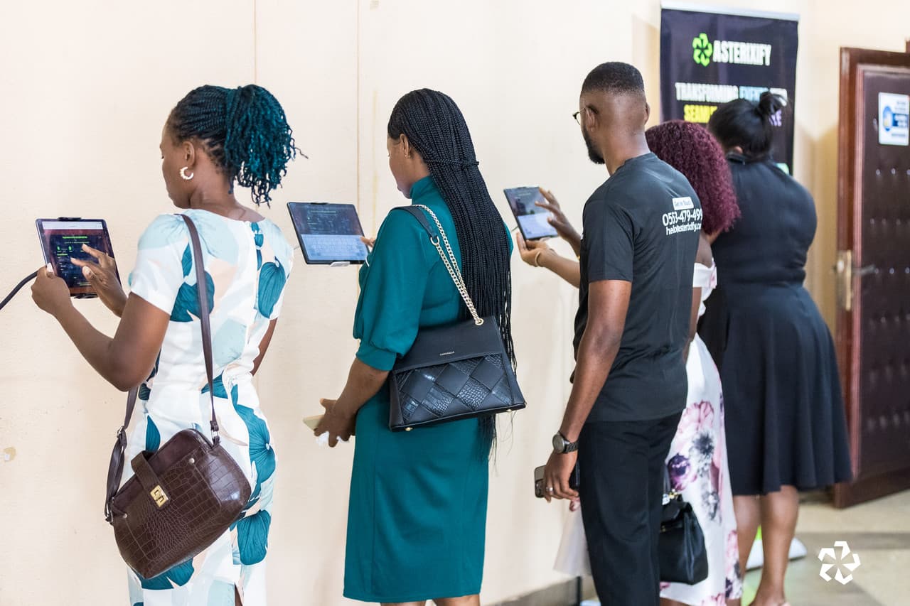 Guests queuing at an Asterixify-staffed on-site registration desk with tablets at a corporate event in Ghana
